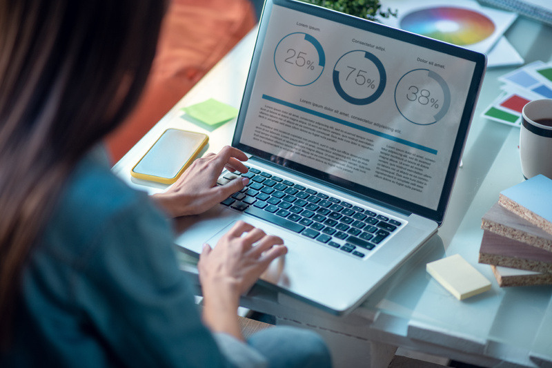 Woman reviews website metrics while working on a computer