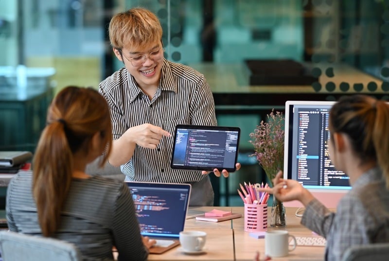 Website team checks over code on their computers