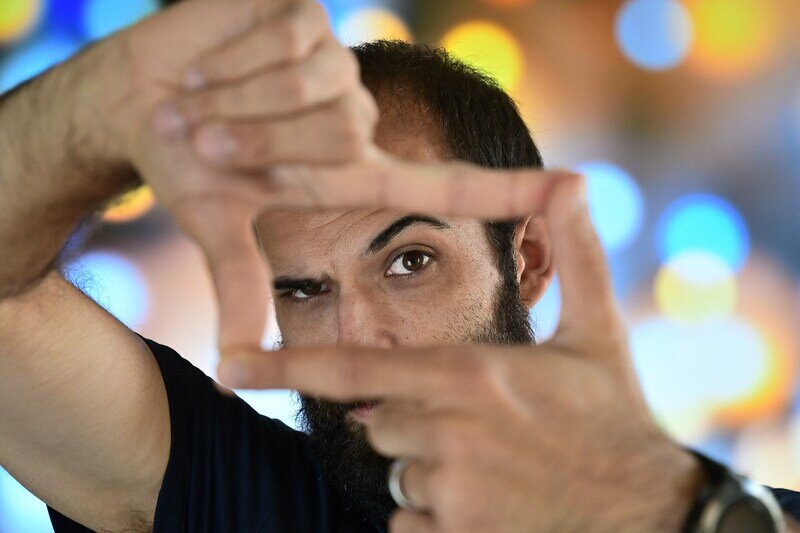 Close up image of a man's face framed with his fingers 